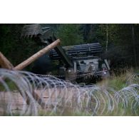 Un véhicule blindé Trojan des Royal Engineers britanniques franchit un chemin miné à Tapa, en Estonie.