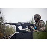 Un soldat sert une mitrailleuse FN Mag en trappe de son petit véhicule protégé (PVP) à Tapa, en Estonie.