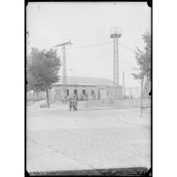 30 Juillet 1915. Le Bourget. Poste de l'entrée du parc, à gauche le pylône portant la flèche de toile indicatrice de la direction des vents, à droite, celui portant le phare Zutcher, à feux intermittents. [légende d'origine]
