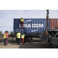 Des manoeuvriers estoniens déchargent un container depuis un train à Tapa, en Estonie.