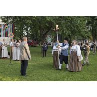 Arrivée de la flamme de l'indépendance portée par des civils en tenue traditionnelle à Tapa, en Estonie.