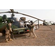 Ravitaillement en carburant d'un hélicoptère de transport Gazelle SA-342 par le personnel navigant britannique sur la piste de la PFOD de Gao.