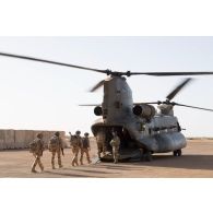 Embarquement de soldats français à bord d'un hélicoptère de transport Chinook CH-47 du détachement d'hélicoptères du Royaume-Uni stationnant sur la piste de la PFOD (plateforme opérationnelle désert) de Gao.
