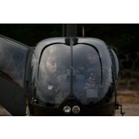 Un opérateur vidéo de la Légion étrangère visite un hélicoptère Robison R44 de l'armée de l'Air estonienne à Kadaga, en Lettonie.