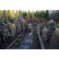 Un instructeur estonien donne un cours de bûcheronnage à des soldats français en forêt de Järvama, en Estonie.
