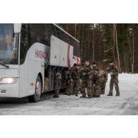 Des soldats embarquent leur équipement à bord d'un car sur l'aéroport d'Amari, en Estonie.
