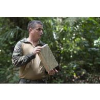 Un instructeur dirige un briefing sur l'utilisation des rations de combat auprès de stagiaires du régiment du service militaire adapté (RSMA) lors d'un atelier bivouac à Saint-Jean-du-Maroni, en Guyane française.
