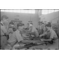 Exercice de montage et de démontage d'un fusil-mitrailleur Bren calibre 303 par des soldats vietnamiens ayant les yeux bandés, à l'école des cadres d'Hanoï.