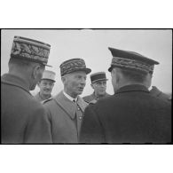 A son arrivée sur l'aéroport de Marignane, le général d'armée Charles Huntziger, secrétaire d'Etat à la Guerre, s'entretient avec les officiers généraux venus l'accueillir.