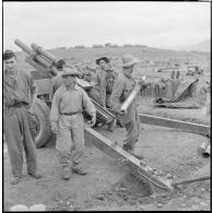 Les artilleurs du régiment d'artillerie coloniale du Maroc (RACM) préparent les charges d'un obusier M2A1 de calibre 105 mm sur un point d'appui au Tonkin.