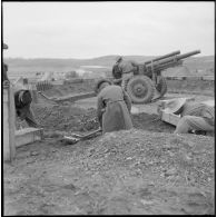 Mise en place d'un obusier M2A1 de calibre 105 mm par des artilleurs du régiment d'artillerie coloniale du Maroc (RACM) sur un point d'appui au Tonkin.