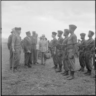 Le général d'armée Jean de Lattre de Tassigny, haut-commissaire et commandant en chef en Indochine, accompagné du général de Linarès, du colonel Sizaire et d'autres officiers, passe en revue des tirailleurs sénégalais.