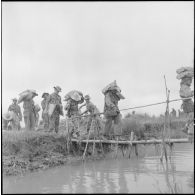 Franchissement d'un arroyo sur un pont de fortune par une compagnie de parachutistes au cours de l'opération Méduse.