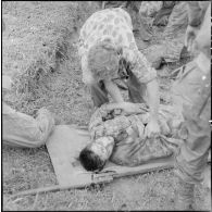 Installation d'un parachutiste blessé au cours de l'opération Méduse sur un brancard.