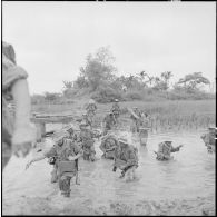 Les troupes franco-vietnamiennes franchissent un passage inondé lors de leur progression vers le village d'An Binh au cours de l'opération Méduse.