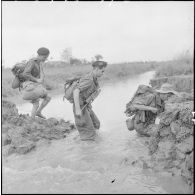 Les troupes franco-vietnamiennes franchissent un arroyo lors de leur progression vers le village d'An Binh au cours de l'opération Méduse.