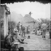 Les troupes ayant passé la nuit dans le village d'An Lao préparent le café tandis que le commandant Fourcade transmet par radio les différentes instructions pour la marche à suivre dans la journée.