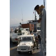 Véhicules embarqués sur une barge de l'armée libanaise sur un quai du port de Beyrouth : Peugeot P4, VAB SAN (véhicule de l'avant blindé sanitaire), camion VTL (véhicule de transport logistique) du 121e RT(régiment du train), camion GBC 180 avec container 20 pieds. Au premier plan, un militaire libanais.