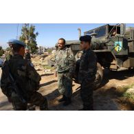 Patrouille à pied dans le village d'At Tiri par un groupe de la 3e compagnie du RMT (régiment de marche du Tchad), appartenant au détachement français de la FINUL (Force intérimaire des Nations unies au Liban). Discussion avec des militaires libanais devant un camion REO M809 Series.