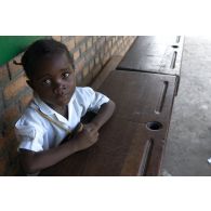 Les écoliers aident à la livraison des bancs dans une école d'un quartier populaire de la ville de Kinshasa.