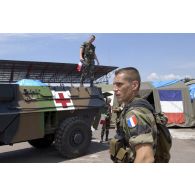 VAB sanitaire - un soldat accroche le drapeau français sur l'antenne - chargement de matériel.