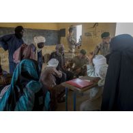 Un médecin du 2e régiment étranger de parachutistes (REP) ausculte un patient à l'école de santé de Ménaka, au Mali.