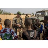 Un officier du 2e régiment étranger de parachutistes (REP) discute avec des enfants de Ménaka, au Mali.