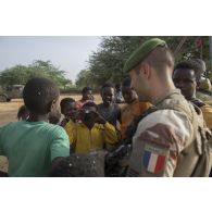 Un officier du 2e régiment étranger de parachutistes (REP) discute avec des enfants de Ménaka, au Mali.