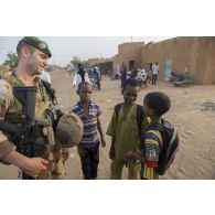 Un officier du 2e régiment étranger de parachutistes (REP) discute avec des enfants dans les rues de Ménaka, au Mali.