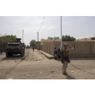 Un soldat estonien fait signe à des civils de laisser le passage libre pour le passage d'un blindé Patria Pasi dans les rues de Gao, au Mali.