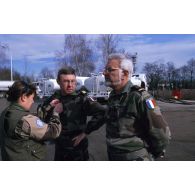 Un sergent-chef de l'ECPA pose un micro-cravate à un commandant qui échange avec un adjudant-chef.
