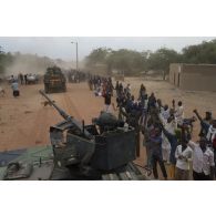 Des habitants accueillent l'arrivée des troupes françaises à bord de leurs véhicules de l'avant blindés (VAB) à Niafounké, au Mali.