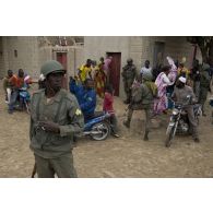 Des soldats maliens sécurisent le périmètre au milieu de la foule venus les saluer à Tombouctou, au Mali.