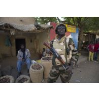 Un chef de groupe nigérien passe devant une boutique du marché lors d'une patrouille dans les rues de Gao, au Mali.