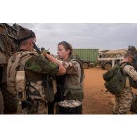 L'opérateur vidéo Marie place un micro-cravate pour l'interview d'un soldat estonien à Gao, au Mali.