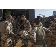 Le personnel du Service de santé des armées (SSA) s'entraîne à embarquer un brancard à bord d'un véhicule blindé de combat d'infanterie (VBCI) équipé d'un kit sanitaire dans un atelier de Gao, au Mali.
