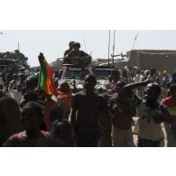 Des marsouins du 2e régiment d'infanterie de marine (2e RIMa) patrouillent à bord d'un véhicule blindé léger (VBL) au milieu de la foule venue les acclamer à Korioumé, au Mali.