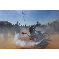 Un civil malien fait fumer sa moto au passage des troupes françaises à Korioumé, au Mali.