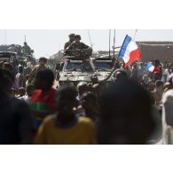 Des marsouins du 2e régiment d'infanterie de marine (2e RIMa) patrouillent à bord d'un véhicule blindé léger (VBL) au milieu de la foule venue les acclamer à Korioumé, au Mali.