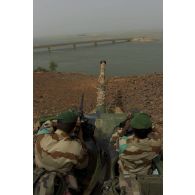 Des légionnaires du 1er régiment étranger de cavalerie (1er REC) sécurisent le périmètre à bord d'un engin blindé à roues, canon de 90 mm (ERC-90) Sagaie autour du pont de Wabaria, au Mali.