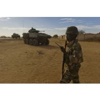 Des soldats nigériens mènent une reconnaissance d'axe routier aux côtés d'un véhicule blindé de combat d'infanterie (VBCI) du 92e régiment d'infanterie (92e RI) aux alentours de Bourem, au Mali.