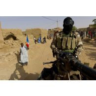 Un militaire malien sécurise le périmètre au moyen d'une mitrailleuse lourde DShK à l'arrière d'un pick-up lors de la traversée de Bourem, au Mali.