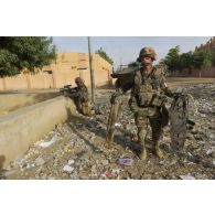 Un soldat du 92e régiment d'infanterie (92e RI) récupère une ceinture d'explosifs trouvée parmi les décombres d'immeubles à Gao, au Mali.