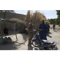 Un marsouin du 21e régiment d'infanterie de marine (21e RIMa) discute avec un habitant de Markala, au Mali.