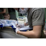 Un médecin prend des notes sur l'état d'un blessé au Rôle 2 de Gao, au Mali.