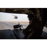 Un hélicoptère Caïman NH-90 assure la sécurité du vol d'un hélicoptère britannique Chinook Ch-47 à Gao, au Mali.