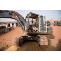 Un sapeur du 19e régiment du génie (RG) aménage l'accès à un poste de combat à bord d'une pelle hydraulique à Gossi, au Mali.