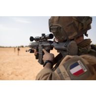 Un soldat du 7e bataillon de chasseurs alpins (BCA) vise au moyen de la lunette de son fusil d'assaut HK-417 dans le secteur de N'Daki, au Mali.