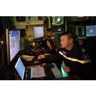 Un technicien radariste surveille ses écrans au centre opérationnel de la frégate Ventôse, en mer des Caraïbes.