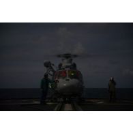 L'équipage de la frégate de surveillance Ventôse prépare un hélicoptère Panther AS-565 de la flottille 36F pour une mission nocturne en mer des Caraïbes.